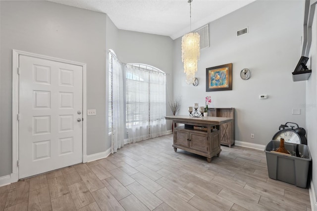 entryway featuring visible vents, light wood finished floors, and baseboards