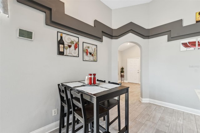 dining area with arched walkways and baseboards