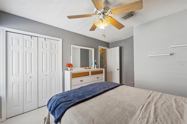 bedroom with a ceiling fan, a closet, a textured ceiling, and visible vents