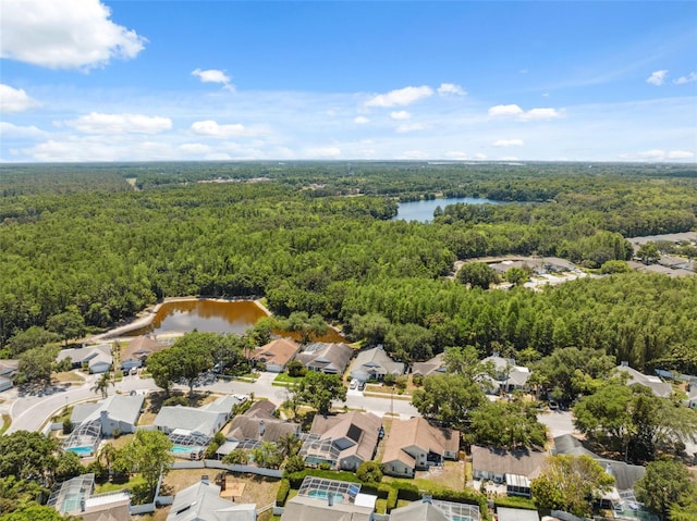 drone / aerial view featuring a water view, a residential view, and a wooded view