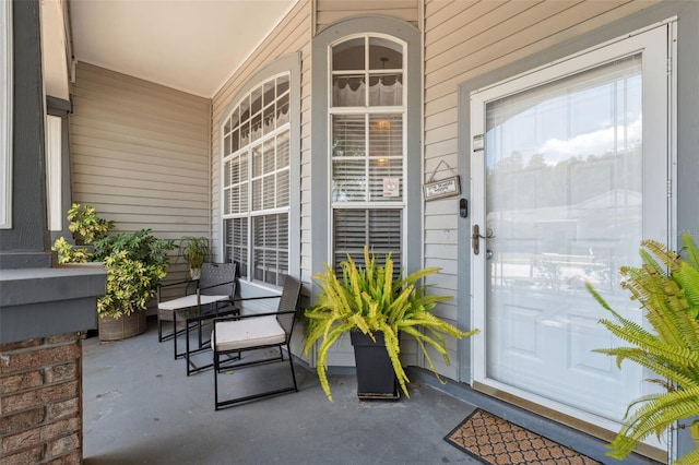 view of exterior entry featuring covered porch