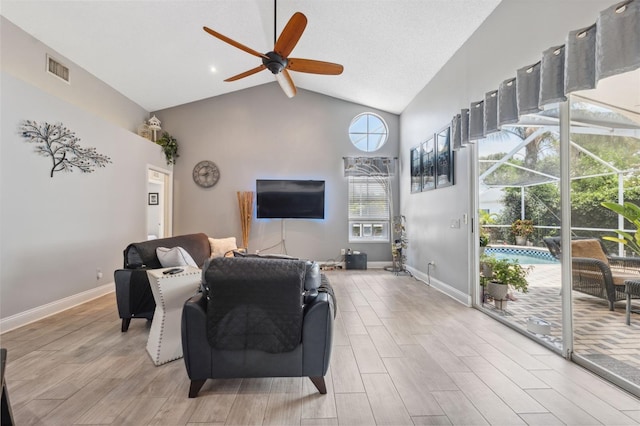 living area with ceiling fan, visible vents, high vaulted ceiling, baseboards, and light wood finished floors