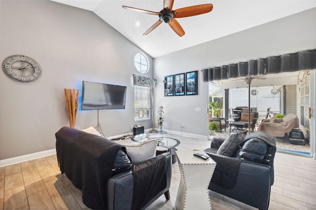 living area with ceiling fan, baseboards, high vaulted ceiling, and light wood-type flooring