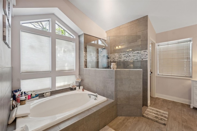 full bath with a walk in shower, a garden tub, wood finished floors, and lofted ceiling