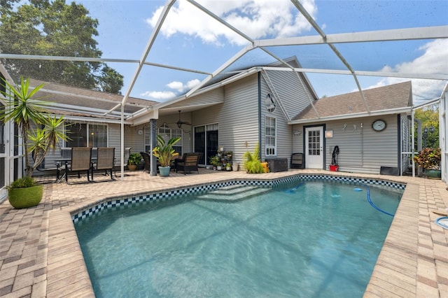 pool with glass enclosure, a patio area, and outdoor dining space