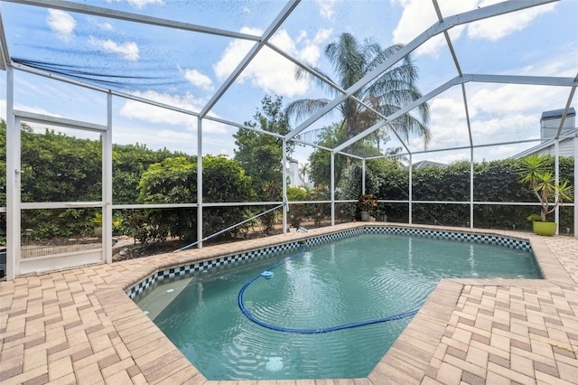 pool with glass enclosure and a patio area