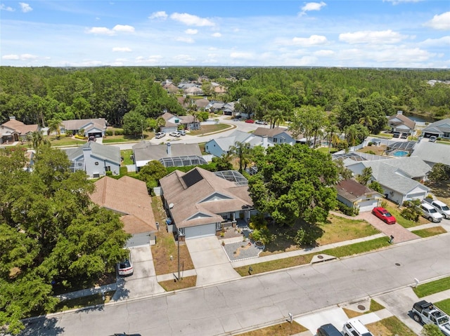 drone / aerial view featuring a residential view and a wooded view