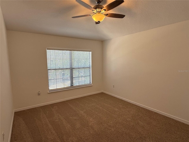 unfurnished room with baseboards, ceiling fan, and dark colored carpet