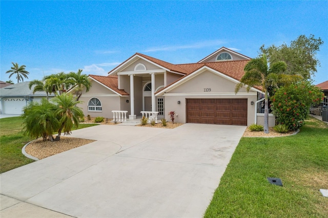 1109 SW 44th St, Cape Coral, FL 33914 - view of front of house featuring a garage, driveway, a front yard, and stucco siding