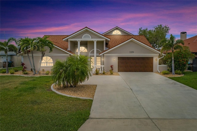 1109 SW 44th St, Cape Coral, FL 33914 - view of front of house featuring an attached garage, stucco siding, driveway, and a yard
