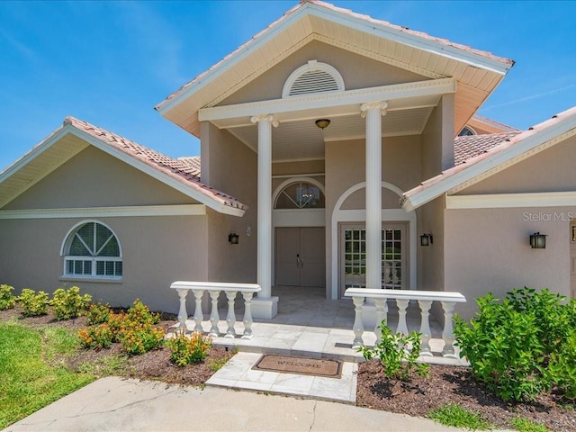1109 SW 44th St, Cape Coral, FL 33914 - property entrance featuring a porch, stucco siding, and a tile roof