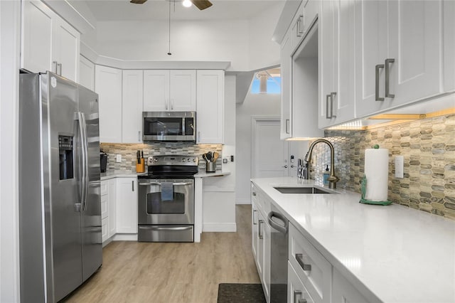 1109 SW 44th St, Cape Coral, FL 33914 - kitchen featuring stainless steel appliances, a sink, tasteful backsplash, light countertops, and light wood-style floors