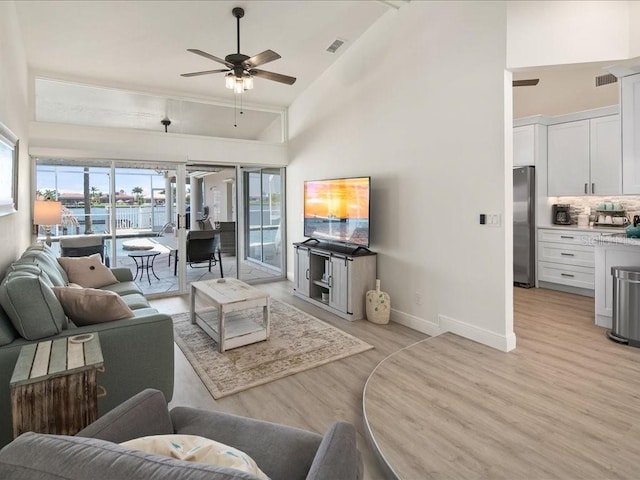 1109 SW 44th St, Cape Coral, FL 33914 - living room with light wood-style floors, a ceiling fan, baseboards, and high vaulted ceiling