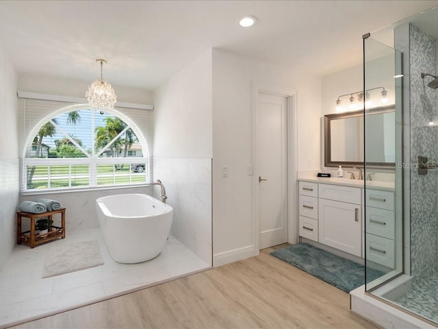1109 SW 44th St, Cape Coral, FL 33914 - bathroom featuring a shower stall, vanity, wood finished floors, a freestanding tub, and a chandelier