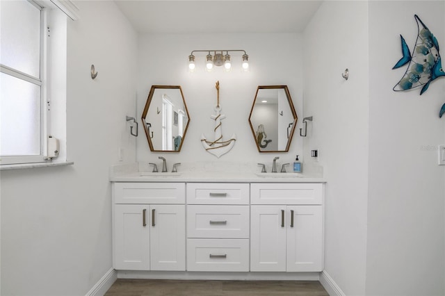1109 SW 44th St, Cape Coral, FL 33914 - full bathroom featuring wood finished floors, double vanity, and baseboards