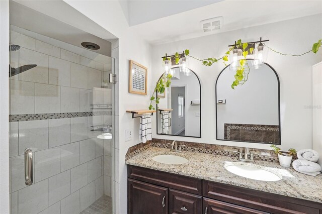 bathroom with double vanity, a sink, and a shower stall