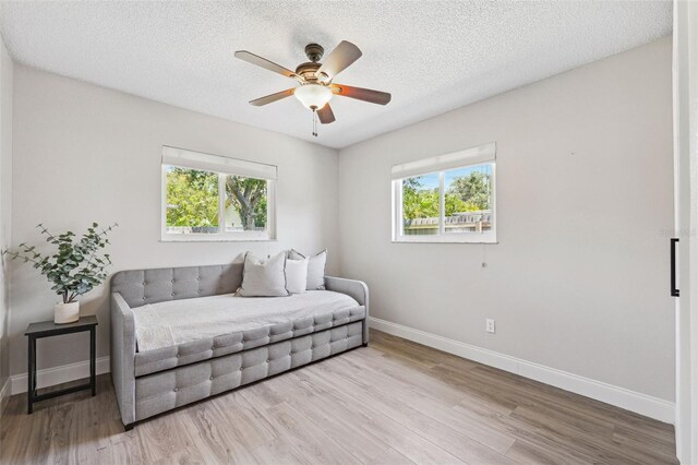 sitting room featuring baseboards, plenty of natural light, and wood finished floors