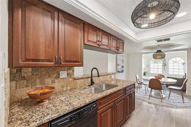 kitchen featuring dishwasher, light stone counters, a sink, light wood finished floors, and backsplash