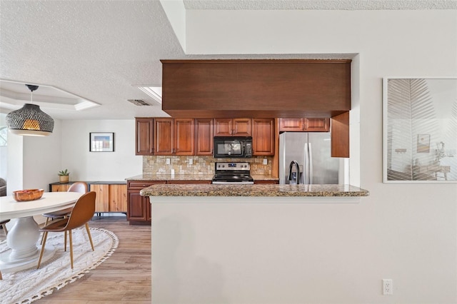 640 Kenneth Way, Tarpon Springs, FL 34689 - kitchen with visible vents, a textured ceiling, tasteful backsplash, light wood finished floors, and appliances with stainless steel finishes