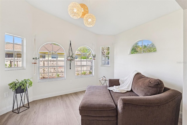 640 Kenneth Way, Tarpon Springs, FL 34689 - living area featuring a healthy amount of sunlight, baseboards, wood finished floors, and a notable chandelier