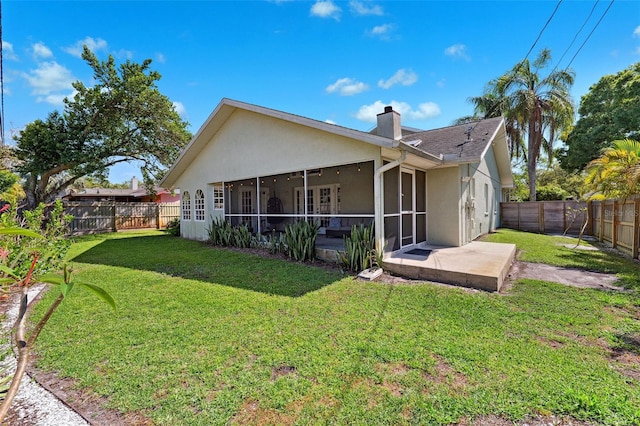 640 Kenneth Way, Tarpon Springs, FL 34689 - back of property featuring a yard, a chimney, a sunroom, and stucco siding