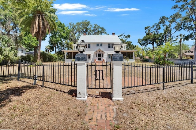 5603 Palmetto Rd, New Port Richey, FL 34652 - view of front of property featuring a fenced front yard, a chimney, and metal roof