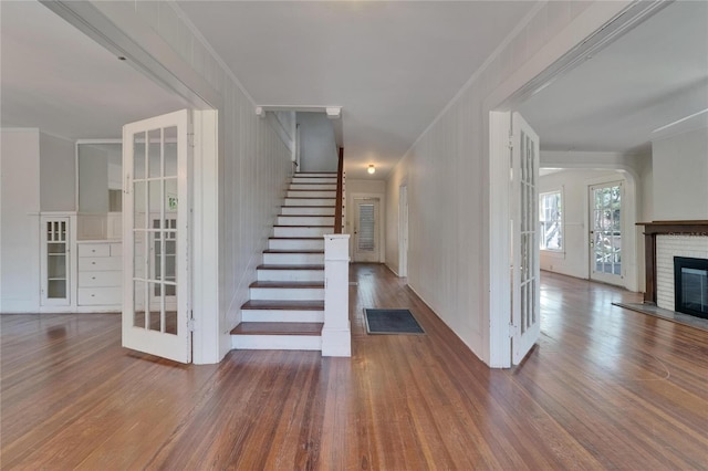 5603 Palmetto Rd, New Port Richey, FL 34652 - stairs featuring french doors, a brick fireplace, and wood finished floors