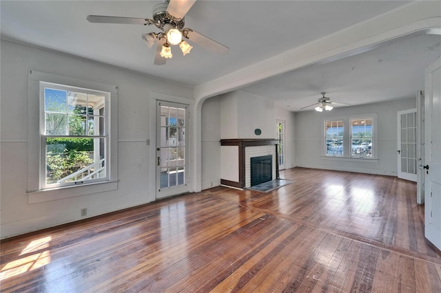 5603 Palmetto Rd, New Port Richey, FL 34652 - unfurnished living room featuring a ceiling fan, wood finished floors, and a brick fireplace