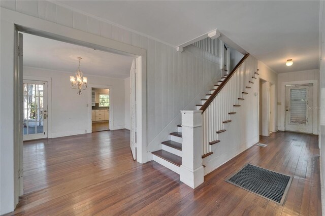 5603 Palmetto Rd, New Port Richey, FL 34652 - staircase with wood-type flooring, crown molding, a chandelier, and visible vents