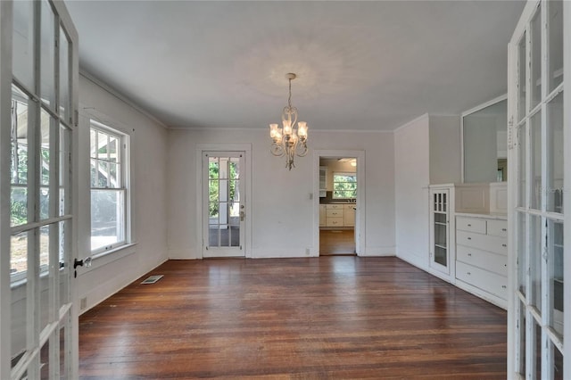 5603 Palmetto Rd, New Port Richey, FL 34652 - unfurnished dining area featuring french doors, an inviting chandelier, wood finished floors, and visible vents