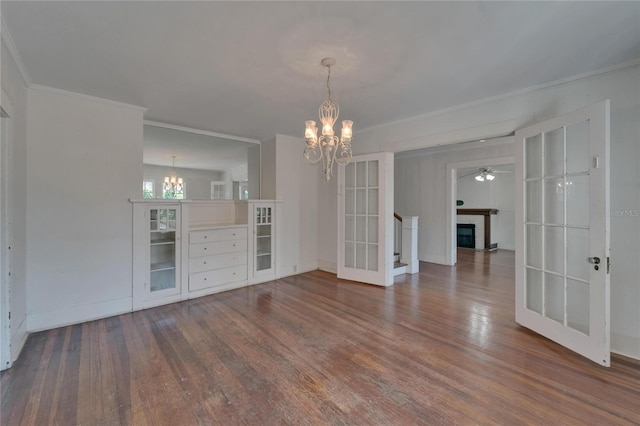 5603 Palmetto Rd, New Port Richey, FL 34652 - unfurnished dining area with crown molding, dark wood-style flooring, baseboards, french doors, and a notable chandelier