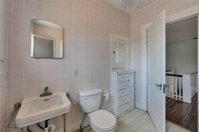 5603 Palmetto Rd, New Port Richey, FL 34652 - bathroom with a sink, tile walls, tile patterned floors, and toilet
