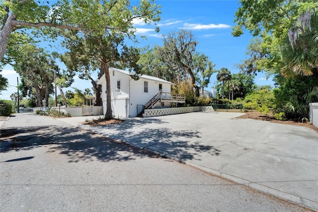 5603 Palmetto Rd, New Port Richey, FL 34652 - view of home's exterior featuring fence, concrete driveway, and stairway