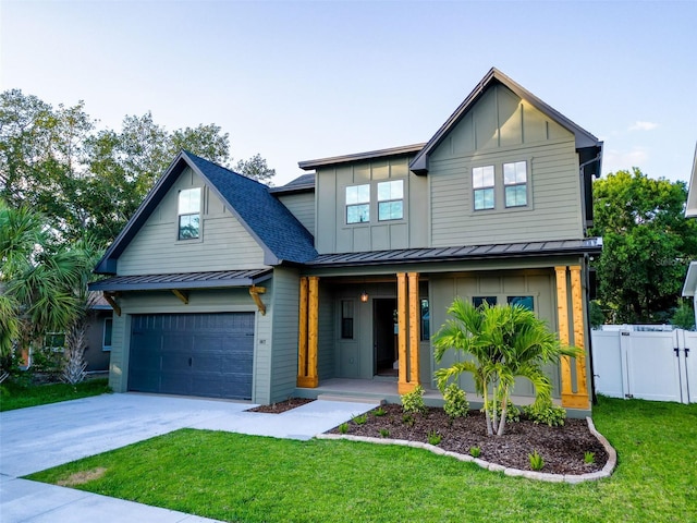 view of front of property with fence, covered porch, a standing seam roof, board and batten siding, and driveway
