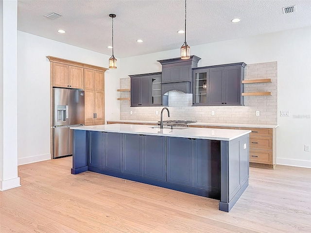 kitchen with open shelves, visible vents, a sink, and stainless steel fridge with ice dispenser