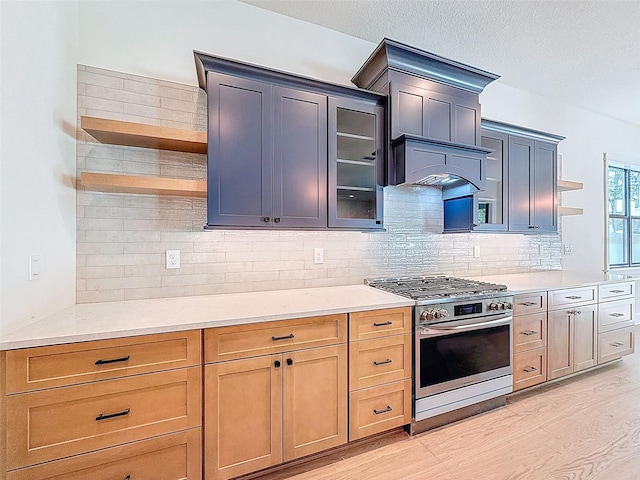 kitchen featuring open shelves, light wood-style flooring, decorative backsplash, and gas range