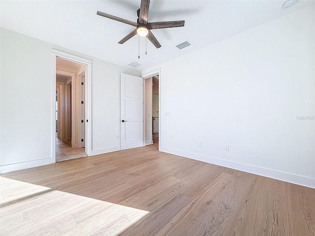 unfurnished bedroom featuring baseboards, light wood finished floors, and visible vents