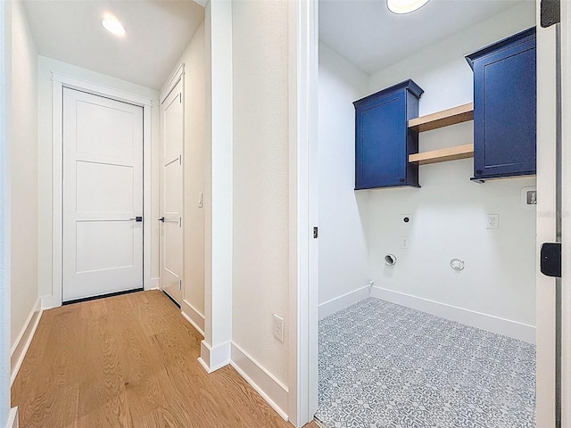 laundry area featuring baseboards, light wood-type flooring, electric dryer hookup, cabinet space, and hookup for a gas dryer
