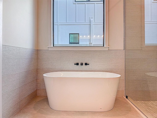 full bath featuring a soaking tub and tiled shower