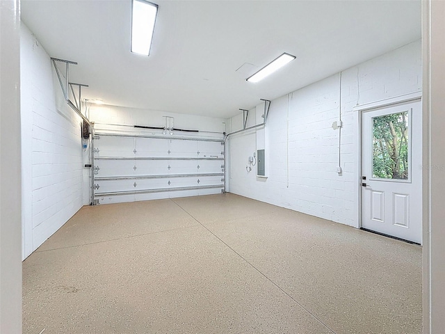garage with electric panel and concrete block wall