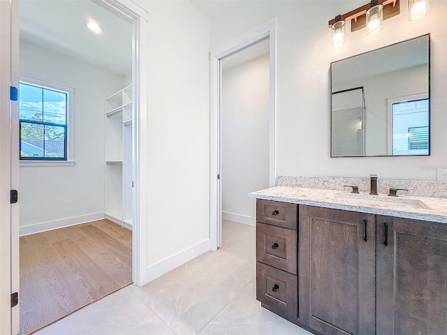 full bathroom featuring vanity and baseboards