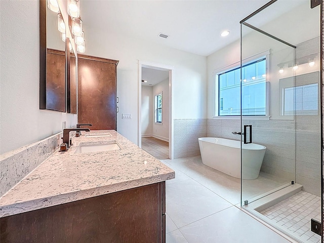 bathroom with visible vents, a freestanding tub, a shower stall, vanity, and tile patterned floors