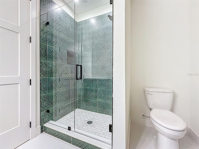 bathroom featuring tile patterned floors, baseboards, a shower stall, and toilet