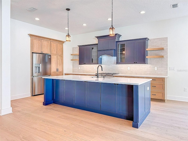 kitchen with stainless steel fridge with ice dispenser, open shelves, and visible vents