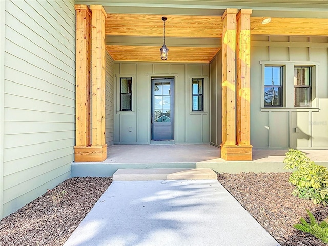 view of exterior entry featuring board and batten siding and covered porch
