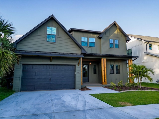 view of front facade with a garage, a front yard, a standing seam roof, board and batten siding, and concrete driveway