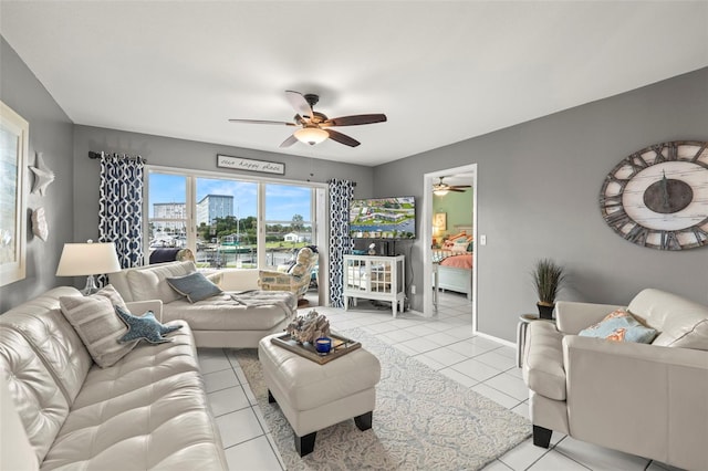 living area featuring baseboards, ceiling fan, and light tile patterned floors