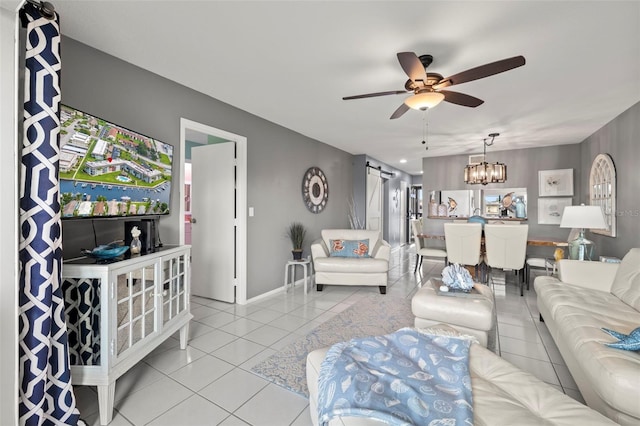 living area with light tile patterned floors, baseboards, and ceiling fan with notable chandelier