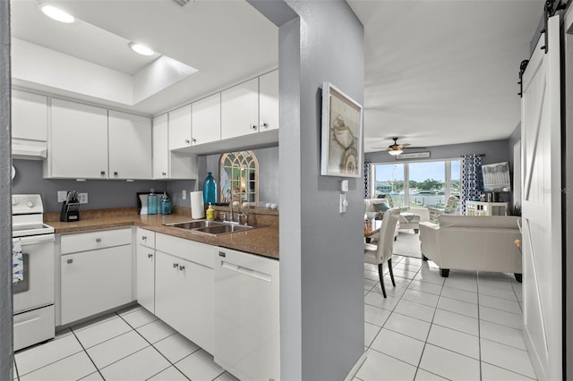 kitchen featuring a sink, light tile patterned floors, white cabinets, and white appliances
