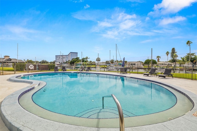 pool with a patio and fence